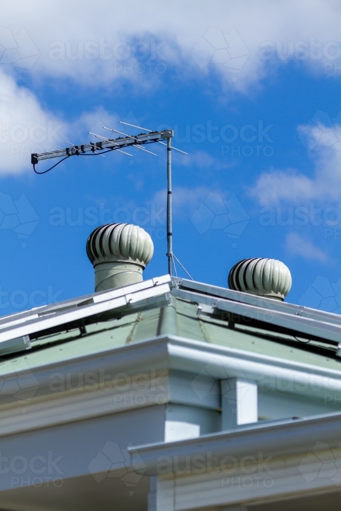 Solar panels, TV antenna, and two roof whirly birds. - Australian Stock Image