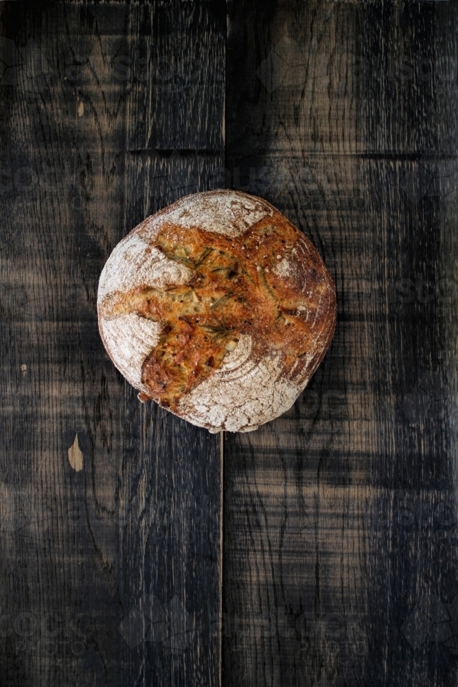 Sourdough loaf of bread on dark background - Australian Stock Image