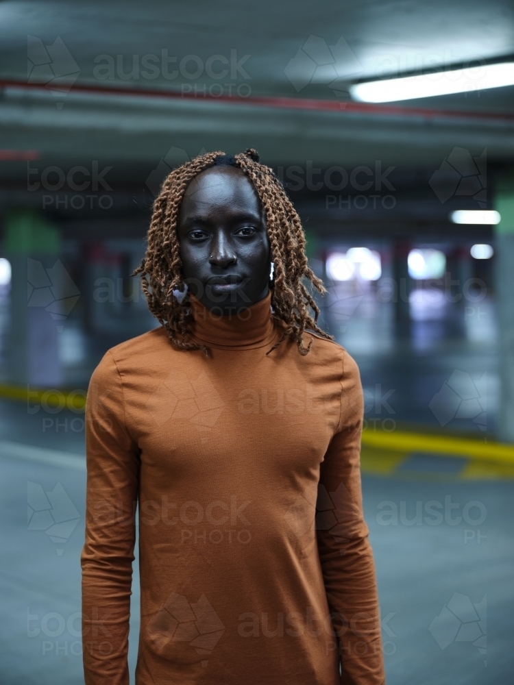 South Sudanese man standing in a carpark - Australian Stock Image