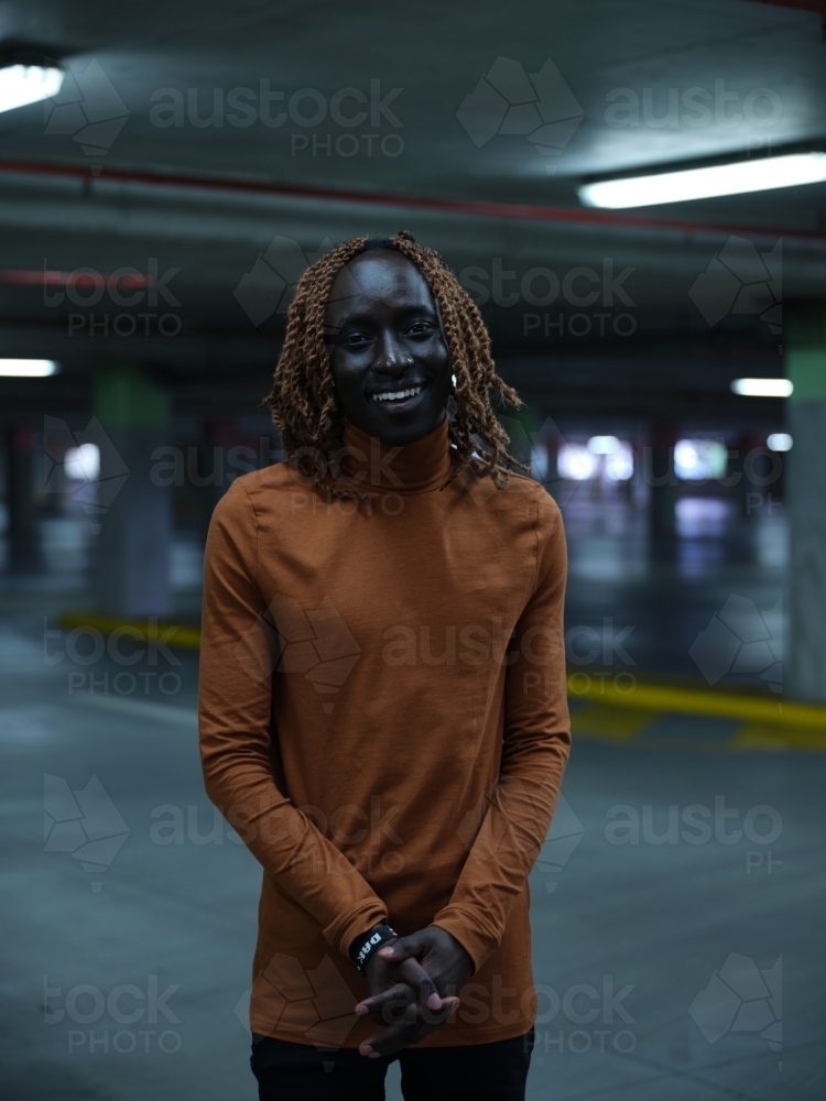 South Sudanese man standing in a carpark - Australian Stock Image