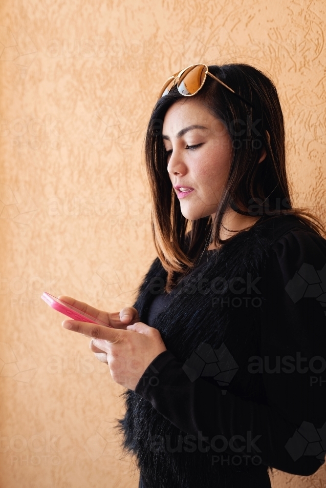 Southeast Asian multicultural woman using mobile phone - Australian Stock Image