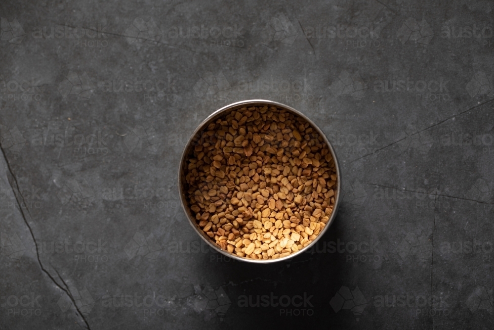 Spice tin of fenugreek seeds top down - Australian Stock Image