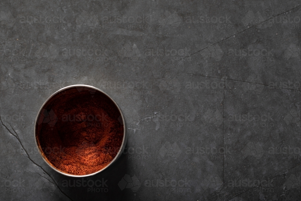 Spice tin of paprika on dark marble background - Australian Stock Image