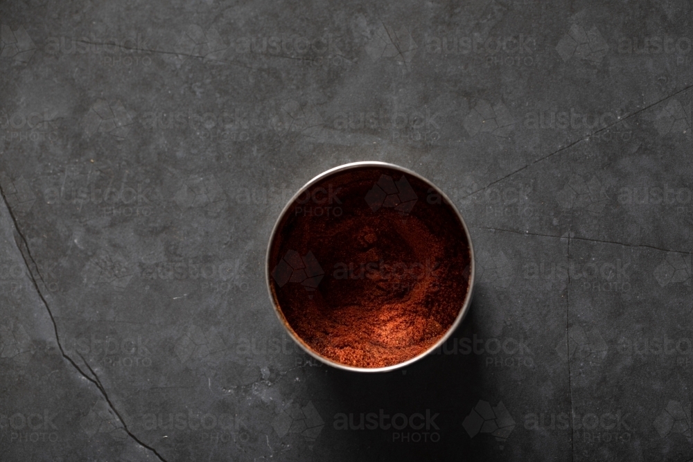 Spice tin of paprika on dark marble background - Australian Stock Image