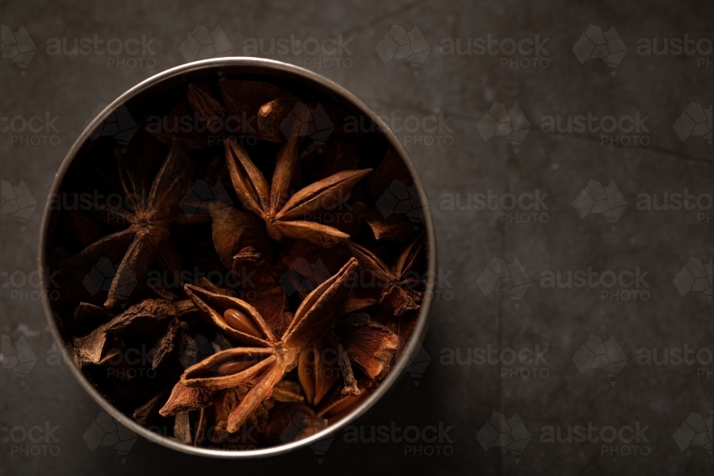 spice tin of star anise on dark marble background - Australian Stock Image