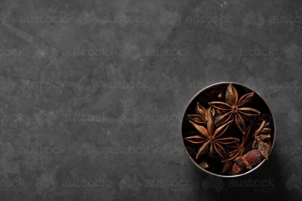 spice tin of star anise on dark marble background - Australian Stock Image