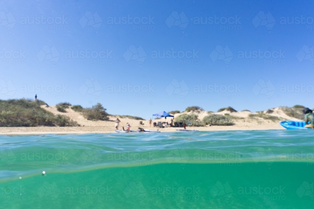 Split shot, half underwater shot, of family enjoying remote beach in Western Australia - Australian Stock Image