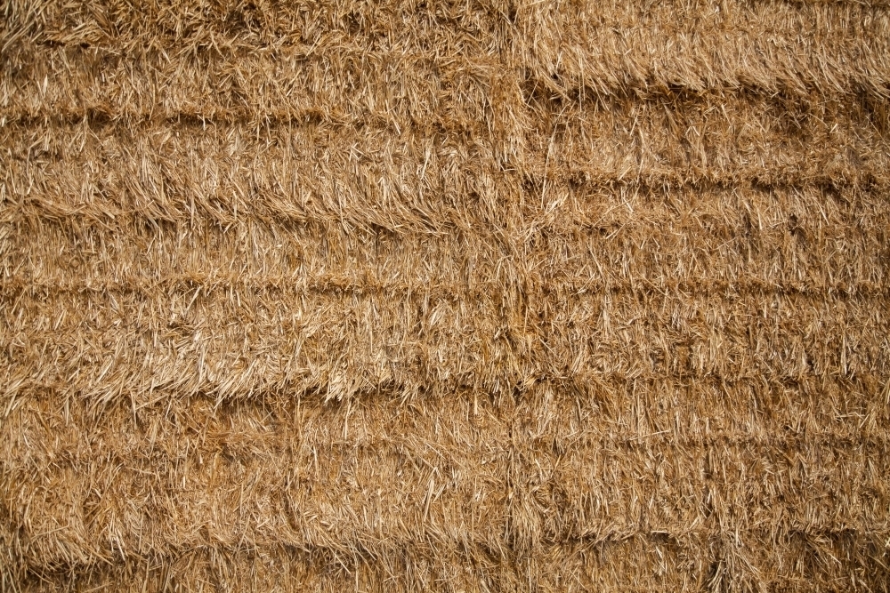 Square bales of hay piled in hay stack texture filling the frame - Australian Stock Image