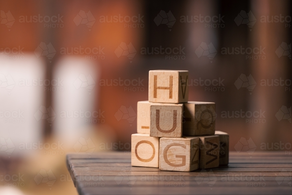 Stack of wooden building blocks with letters on blurred background with copy space - Australian Stock Image