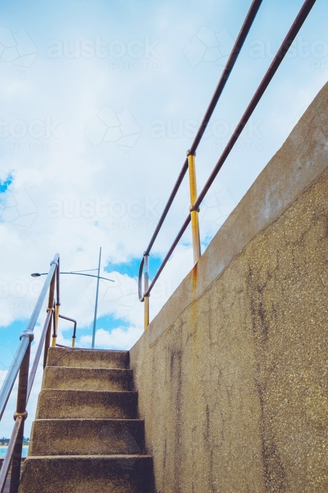 Stairs lead to the top of the seawall - Australian Stock Image