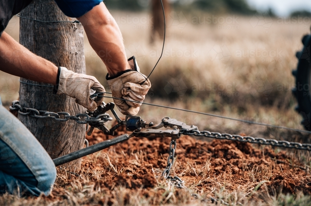 Straining off electric fence post - Australian Stock Image