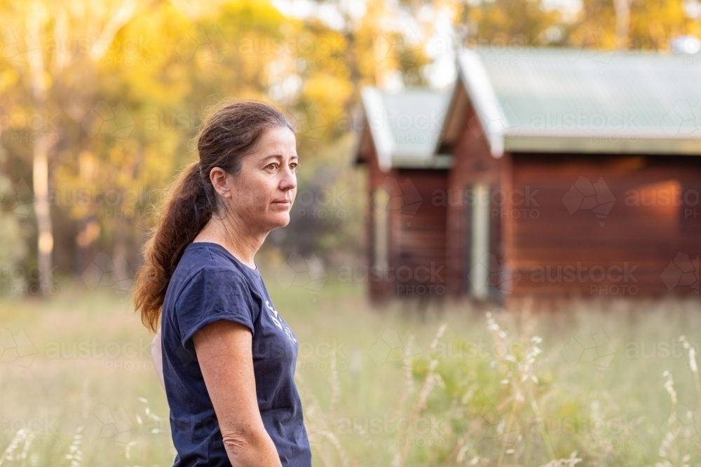 stressed middle-aged woman outside her home - Australian Stock Image