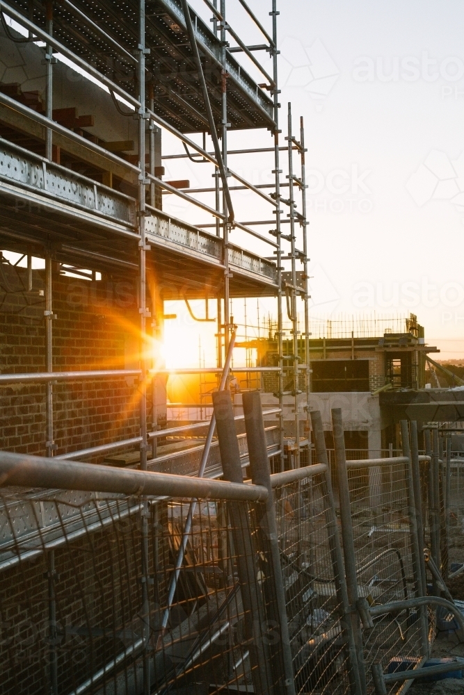 Suburban construction site with machinery and scaffolding, evening sun - Australian Stock Image