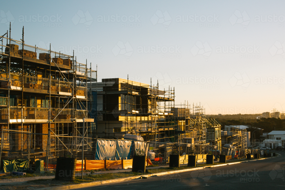 Suburban construction site with machinery and scaffolding, in evening sun - Australian Stock Image