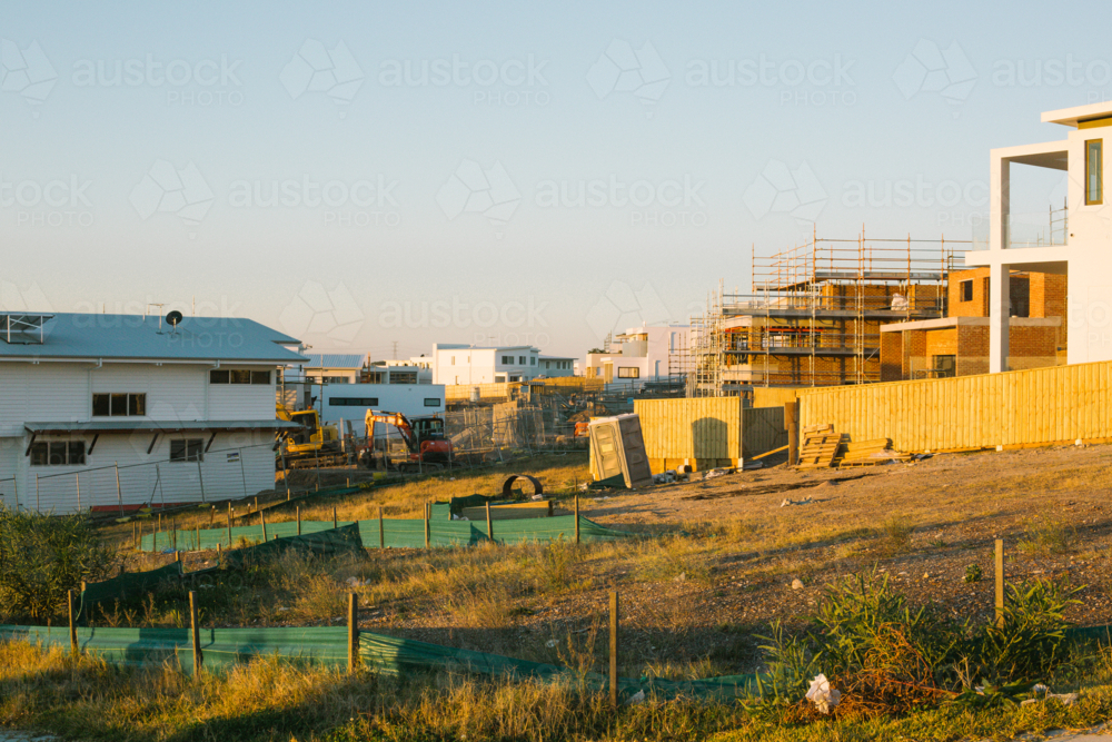 Suburban construction site with machinery and scaffolding, in evening sun - Australian Stock Image