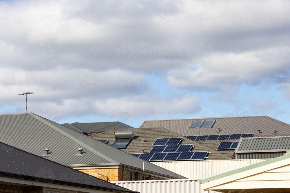 suburban roofs with solar hot water systems, tv antennae and photovoltaic solar panels - Australian Stock Image