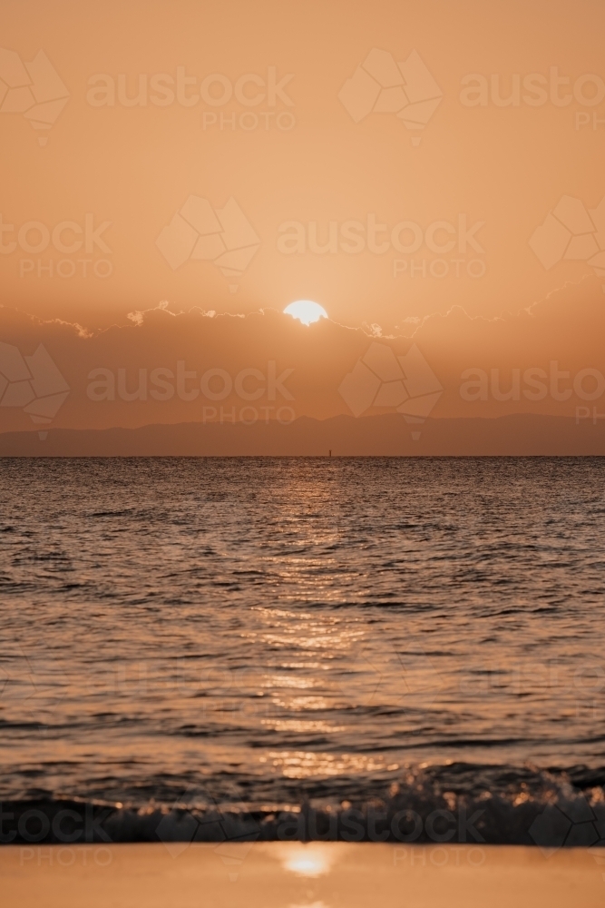 Sun setting behind the clouds over Moreton Bay - Australian Stock Image