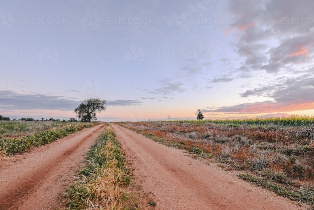 Sun setting on country road in Central Victoria, Australia. - Australian Stock Image