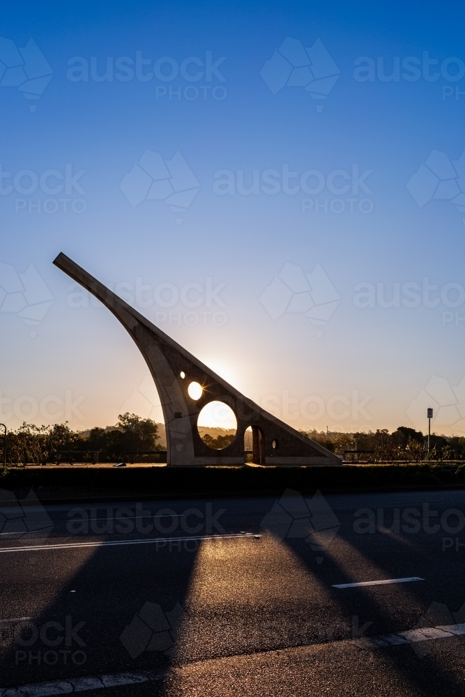 Sundial casting shadow over road at sunset in town of Singleton - Australian Stock Image