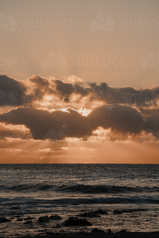 Sunrise through the clouds over the ocean at Bronte Beach - Australian Stock Image