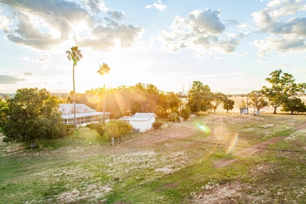 Sunset over a farm homestead and paddock in the country - Australian Stock Image