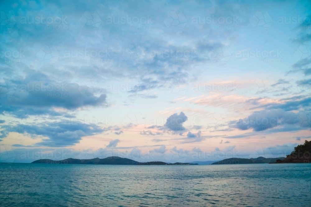 Sunset view of islands off Coral Beach at Shute Harbour in Queensland - Australian Stock Image