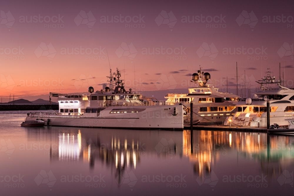 Superyachts at Coral Sea Marina during twilight. - Australian Stock Image