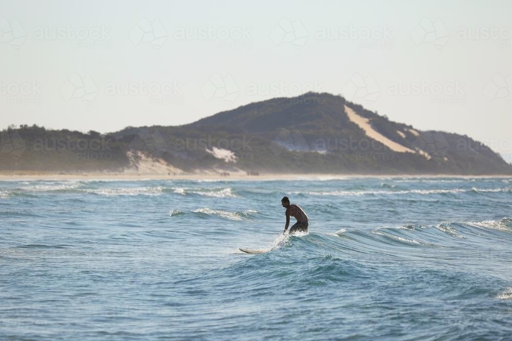 Surfer with mountain in background - Australian Stock Image