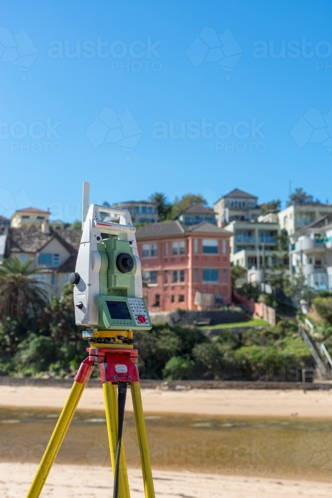 Survey equipment on tripod at beach - Australian Stock Image