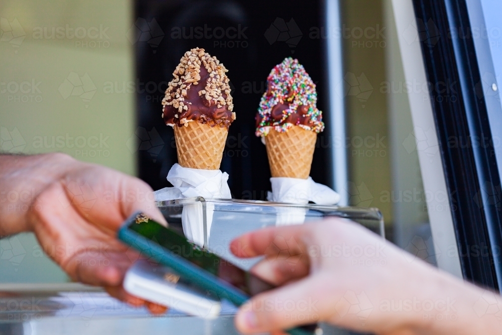 tap to pay transaction on phone to buy ice cream dessert - Australian Stock Image