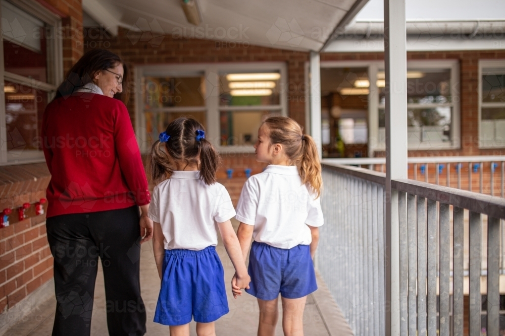 Teacher and Students Walking on Balcony Away from Camera - Australian Stock Image