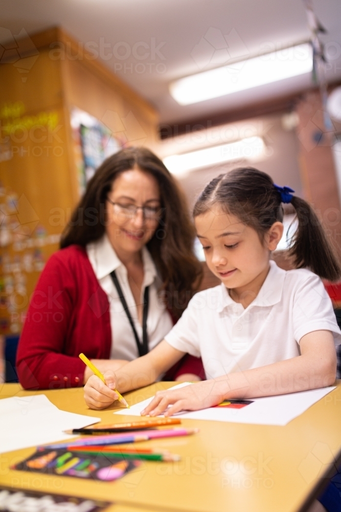 Teacher Helping Young Schoolgirl to Draw - Australian Stock Image