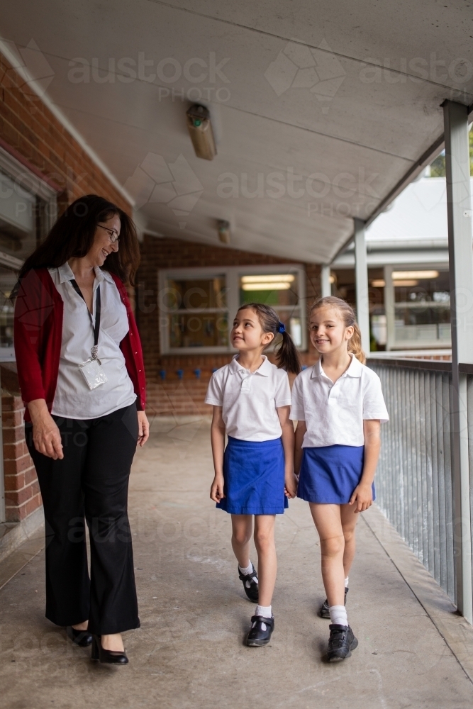 Teacher Walking on Balcony with Two Students - Australian Stock Image