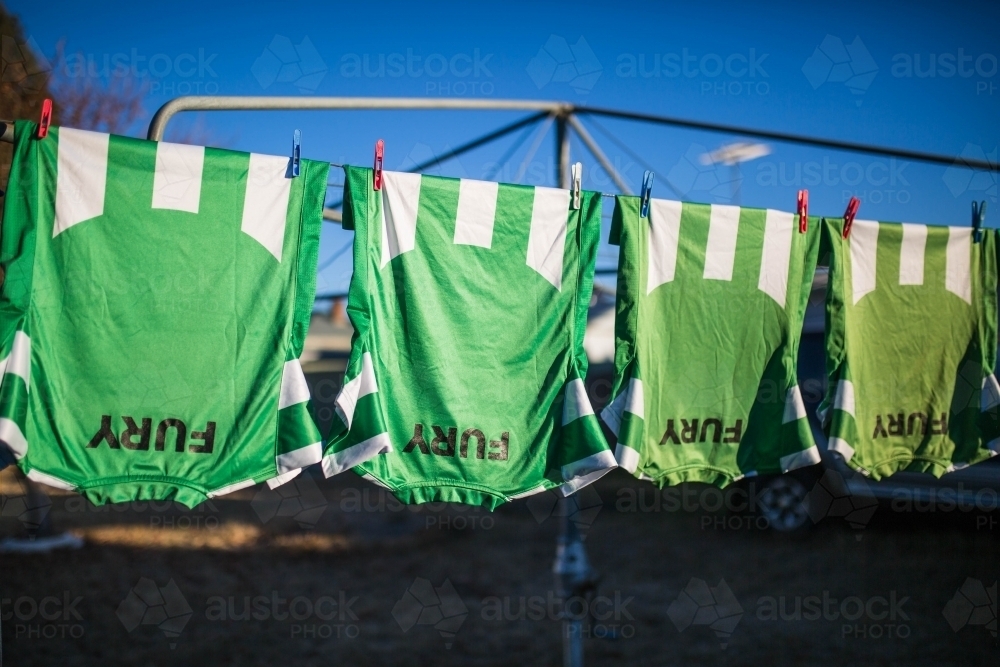 Team shirts hanging on clothes washing line - Australian Stock Image