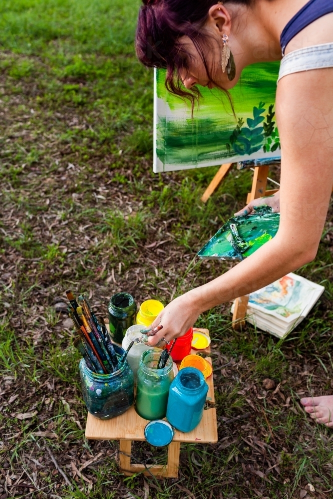 Image of Teen artist with paint pots and brushes - Austockphoto