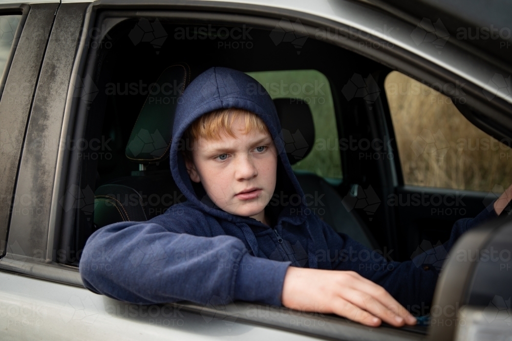 Teen boy driving ute on farm - Australian Stock Image