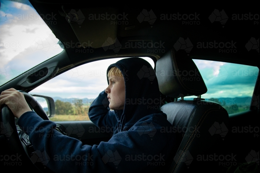 Teen boy driving ute on farm - Australian Stock Image