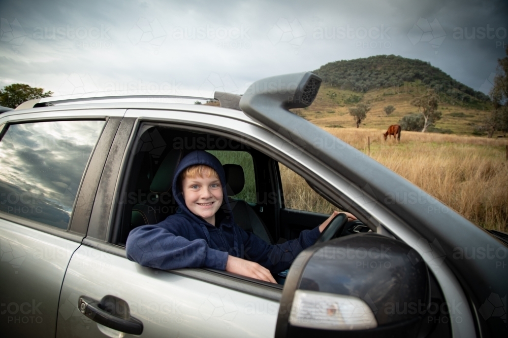 Teen boy driving ute on farm - Australian Stock Image