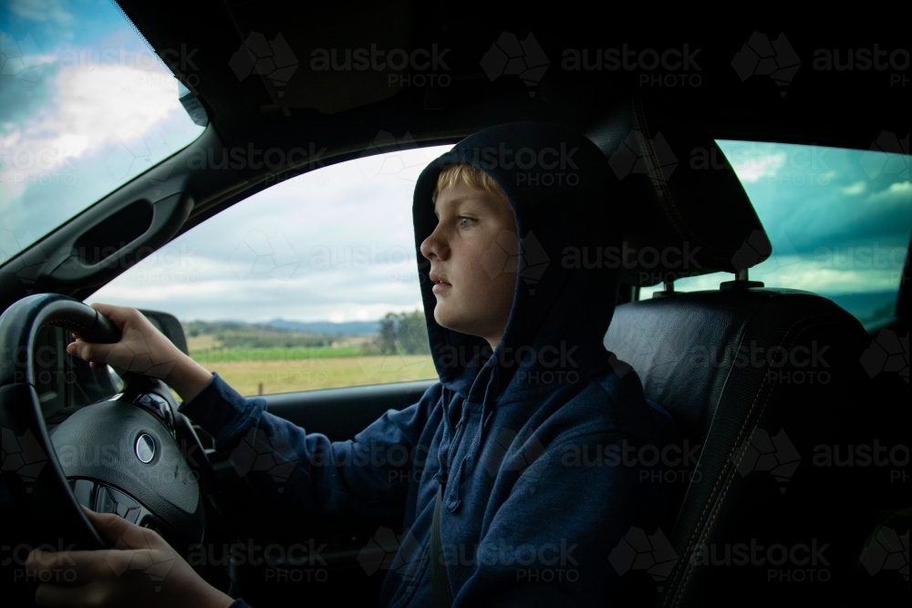 Teen boy driving ute on farm - Australian Stock Image