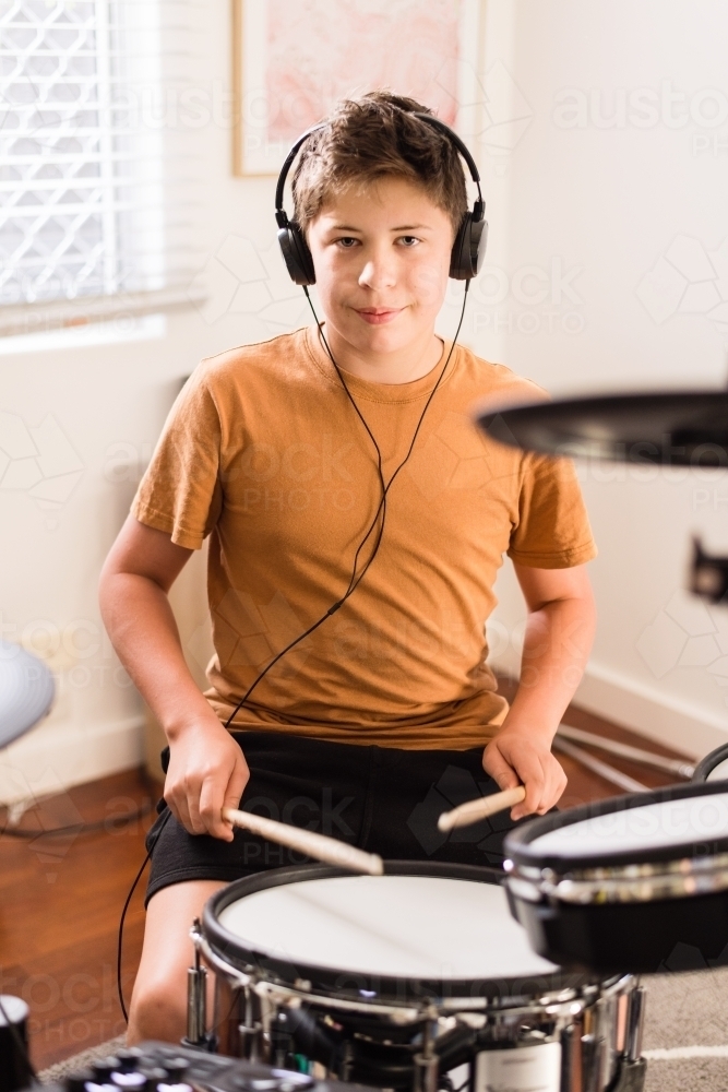 teen boy practising drums at home - Australian Stock Image