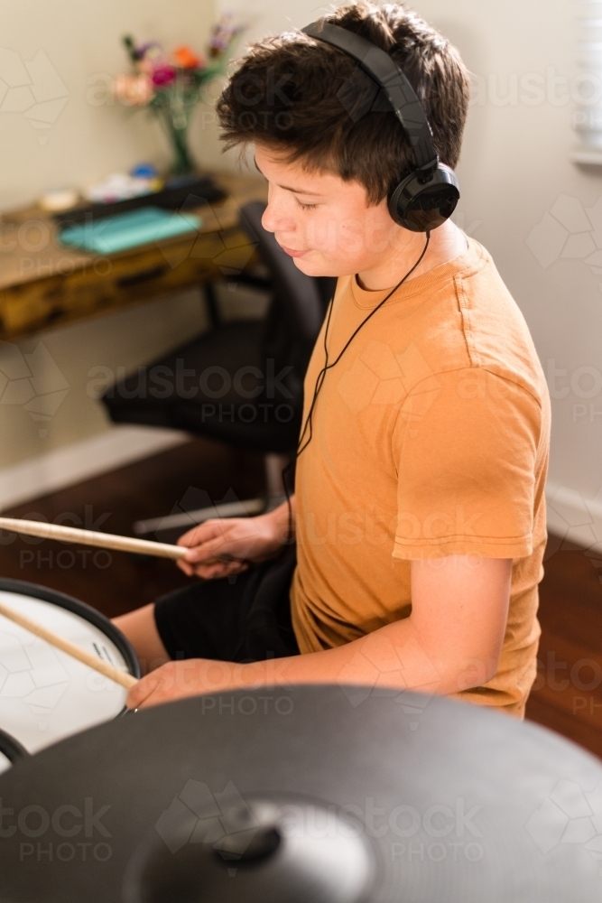 teen boy practising drums at home - Australian Stock Image