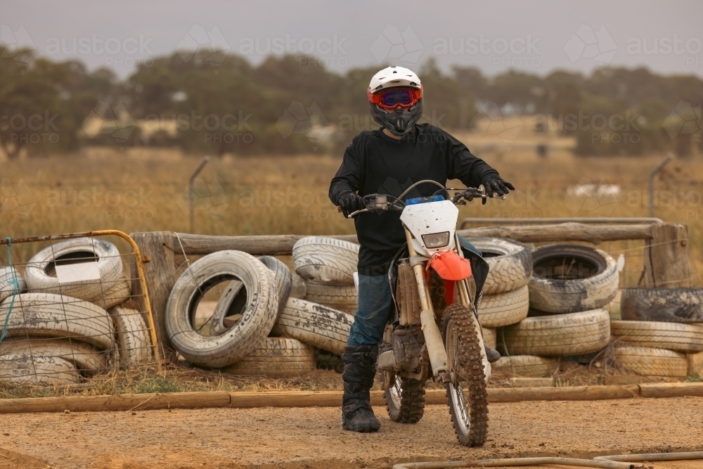 Teen boy riding motorbike at motocross track meet - Australian Stock Image