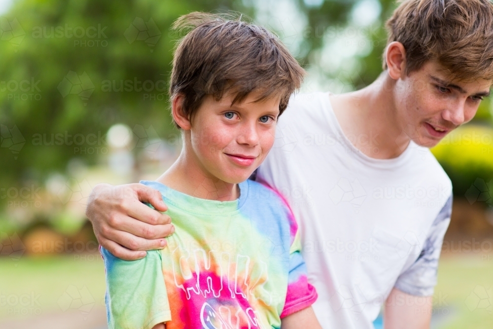 Teen boy with arm around his little brother - Australian Stock Image