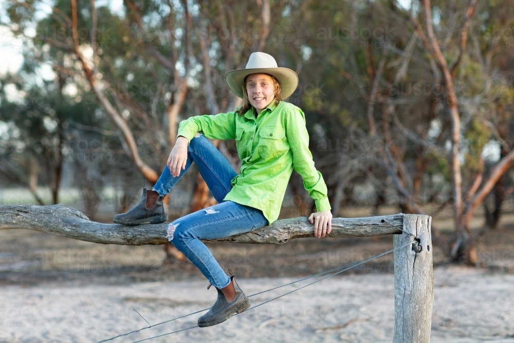 teen country girl sitting on fence - Australian Stock Image