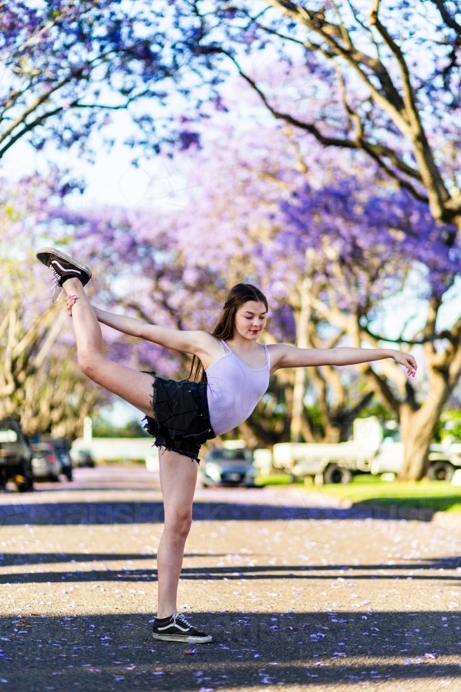 Teen girl dancer standing on the road doing a ballet pose - Australian Stock Image