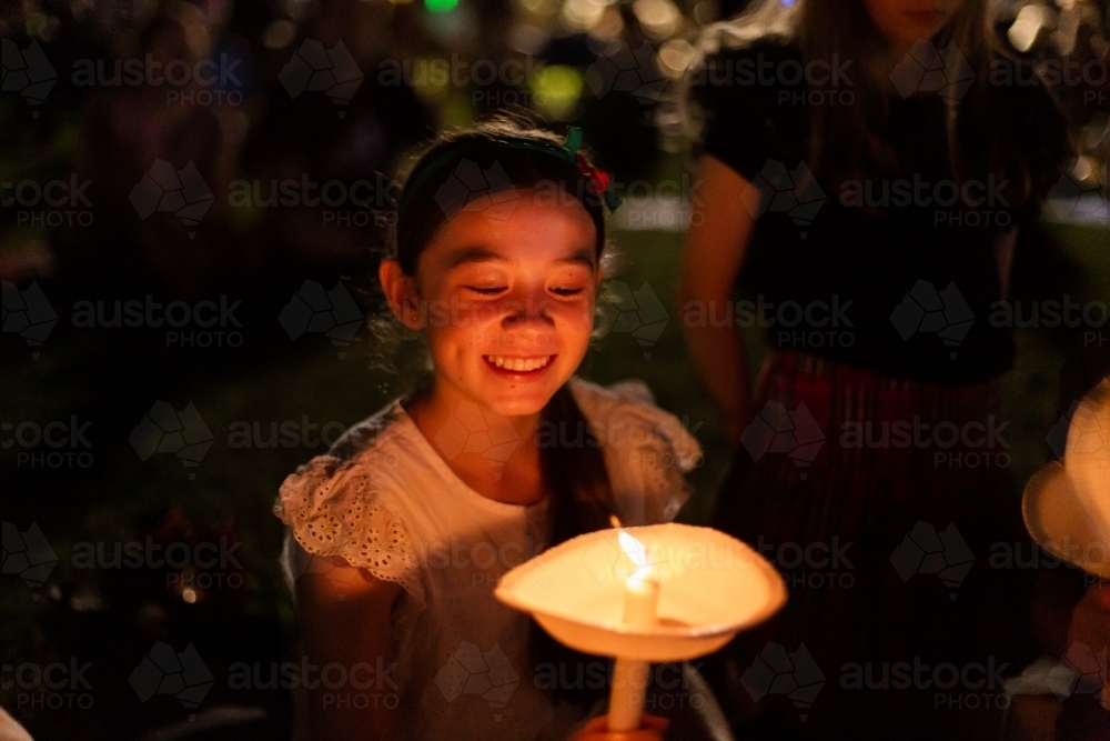 Image of teen girl grinning and looking at her candle at carols by ...