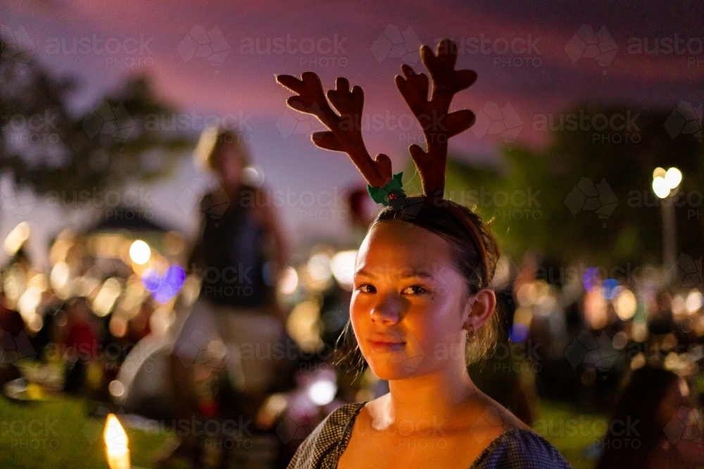 teen girl looking at the camera at christmas carols - Australian Stock Image