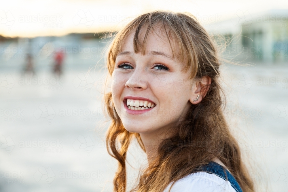 Teen girl looking over her shoulder smiling - Australian Stock Image