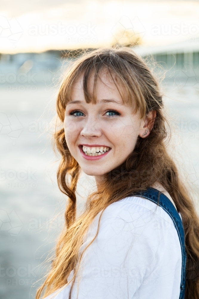 Teen girl looking over her shoulder smiling - Australian Stock Image