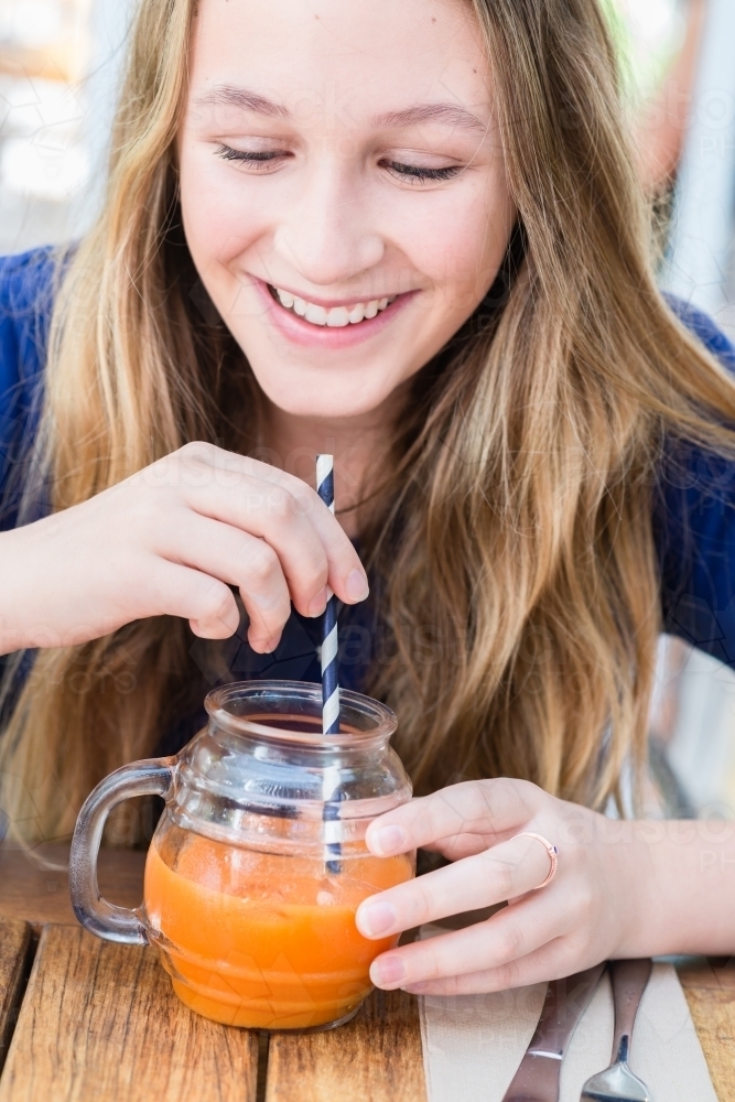 teen girl with fruit juice in cafe - Australian Stock Image